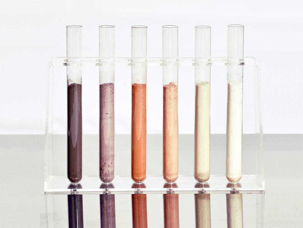 Argilas em pó dispostas em tubos de ensaio. Argilas para a pele: argila preta, roxa, vermelha, rosa, verde, branca. 